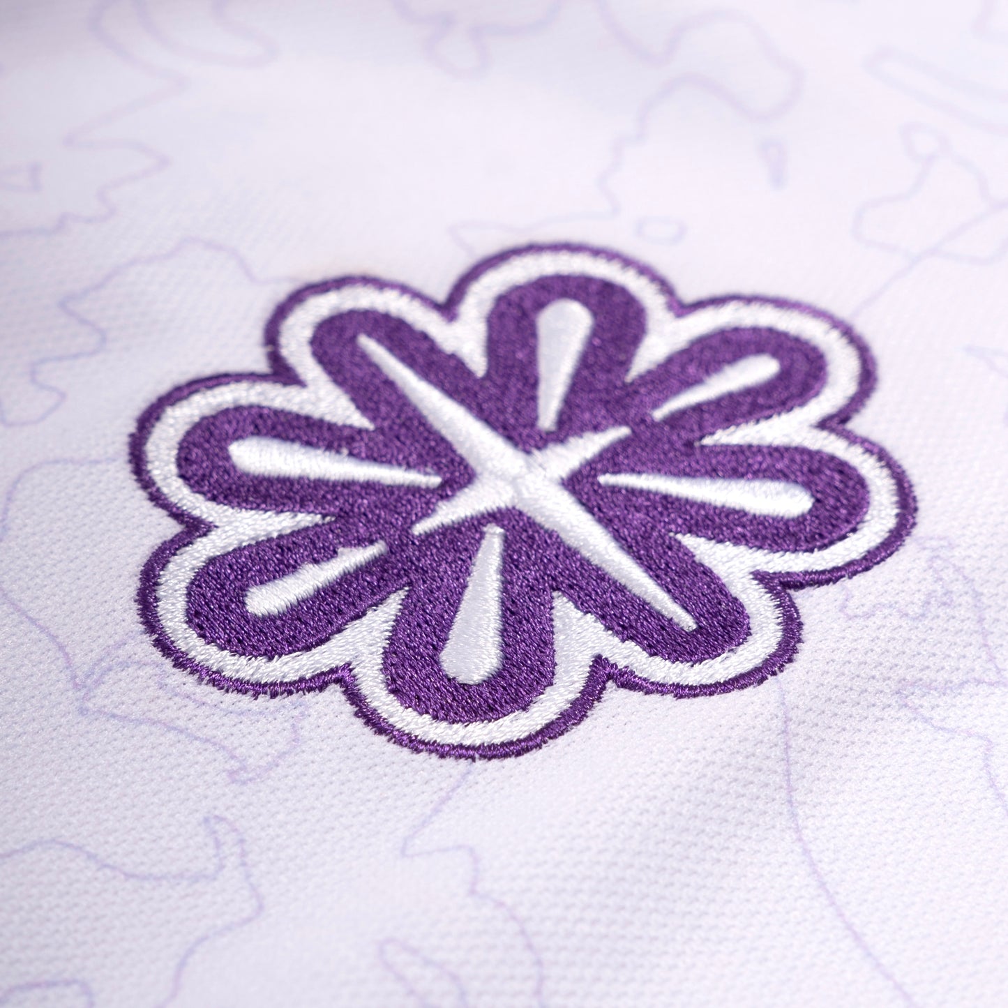 Broderie du logo Steez Club sur maillot blanc - Détail précis en fil violet, ajoutant une touche premium et streetwear à ce vêtement tendance
