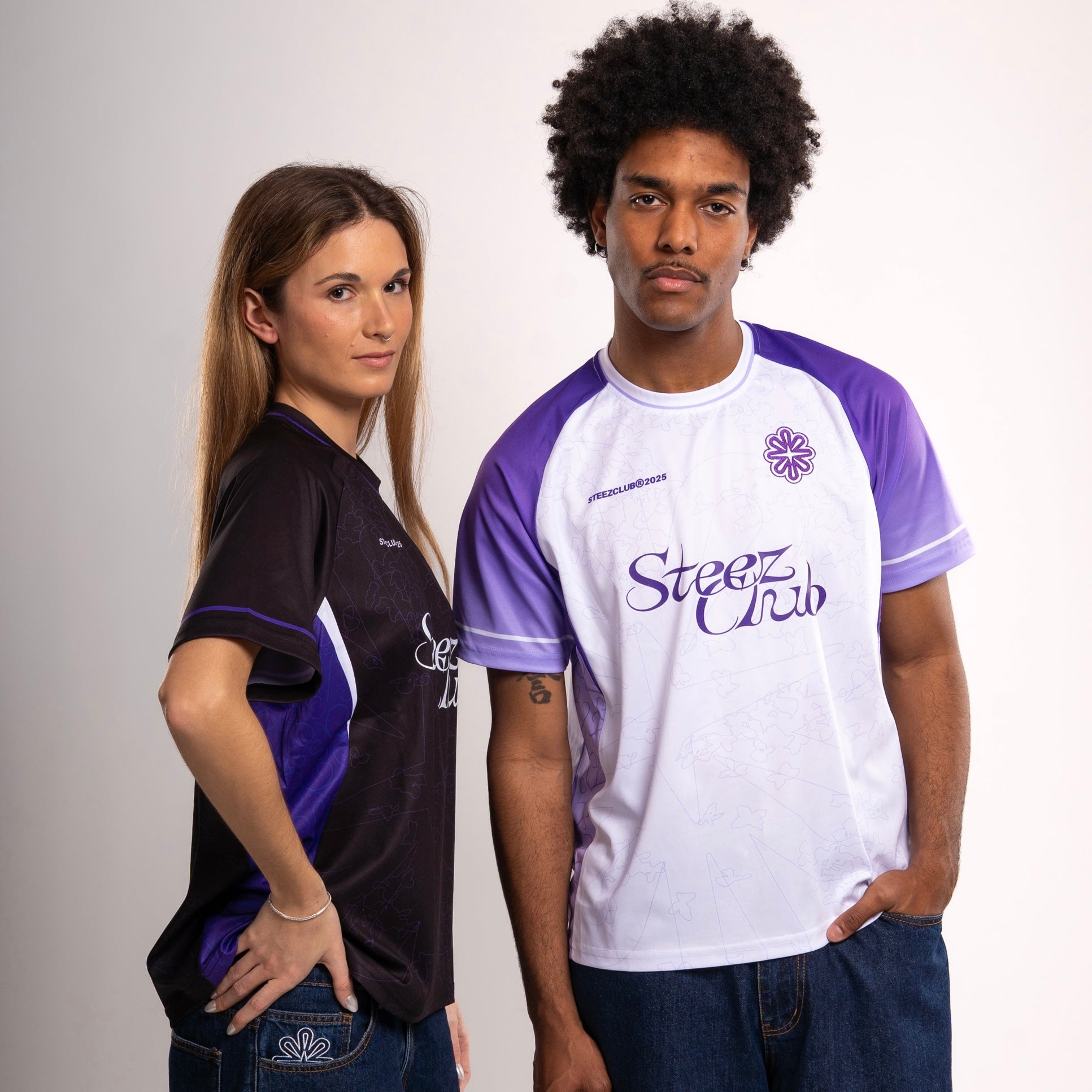 Lookbook Steez Club - Deux mannequins portent les maillots oversize unisexe en noir et en blanc/violet, avec imprimé logo et coupe streetwear. Style urbain, moderne et affirmé.